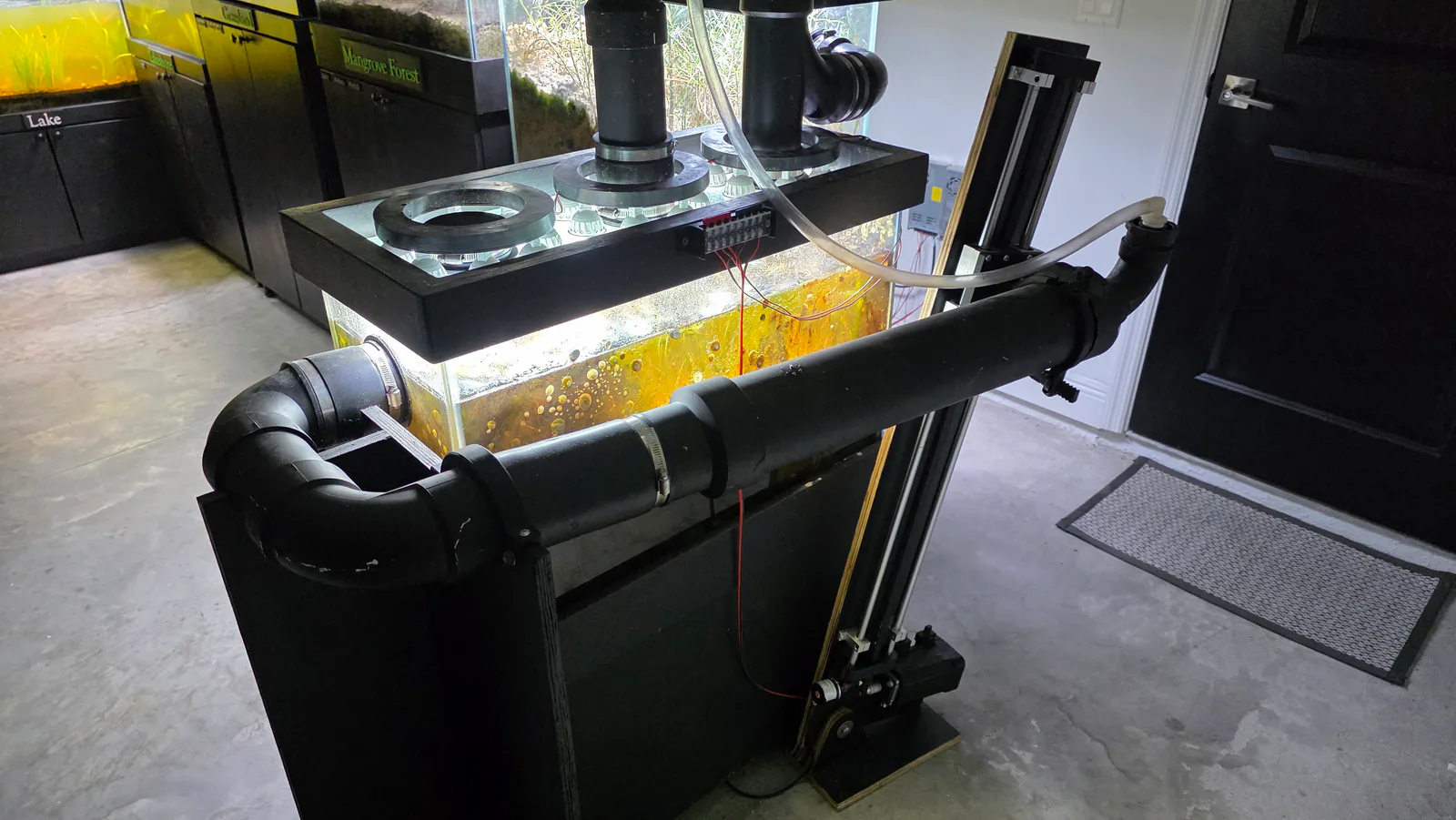 Wave and tide hardware with black plumbing, tubing, and connected habitat tanks.